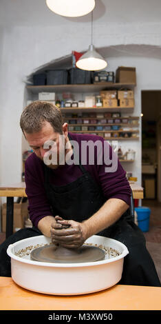 Vue à un artiste fait de la poterie d'argile sur une molette en atelier Banque D'Images