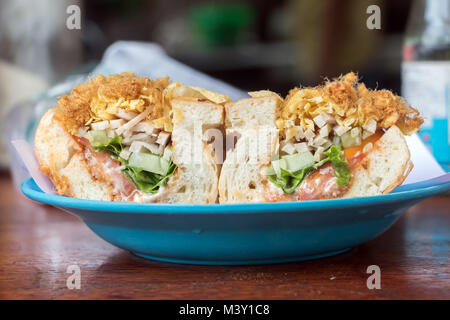 Farcies de légumes sandwich jambon de porc, et les threads, servi sur plaque dans street restaurant à Luang Prabang, Laos. Banque D'Images