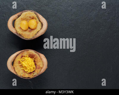 Crème pâtissière à la noix de coco thaï dessert, Maw Gaeng, en pot en argile sur fond sombre Banque D'Images