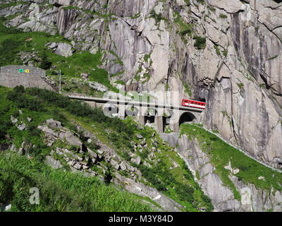 Gotthard Express train sur Teufelsbruecke près de Andermatt en Suisse, Devil's railway bridge and tunnel, Alpes suisses, terres rocheuses alpines Banque D'Images