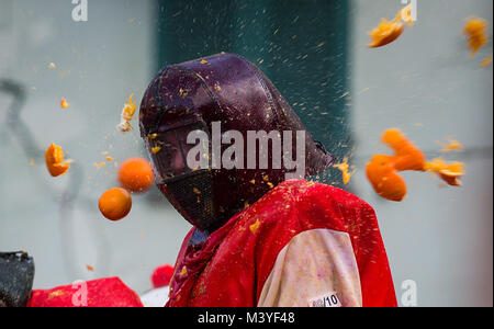 Ivrea, Italie. 12 Février, 2018. Un membre d'une équipe est touchée par les oranges pendant chaque année un carnaval historique 'Bataille des Oranges' dans ville du nord de l'Italie d'Ivrea (Italie), le 12 février 2018. Credit : Jin Yu/Xinhua/Alamy Live News Banque D'Images