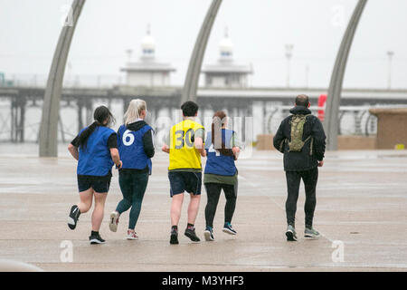 Blackpool, Lancashire. Feb 13, 2018. Météo France : froid, humide et venteux de commencer la journée sur la promenade de front de mer. Normalement, un refuge pour la moitié des visiteurs à long terme cette ans pause à mi-parcours est sans l'Showzam événement qui permet de wow la foule dans les années précédentes. Des pluies torrentielles font qu'il est difficile pour les touristes et visiteurs qui se débattent avec les fortes rafales, et les rafales de vent. La prévision est de poursuivre et de fortes pluies persistantes souvent lentement vers l'est avec des vents forts. /AlamyLiveNews MediaWorldImages : crédit. Banque D'Images