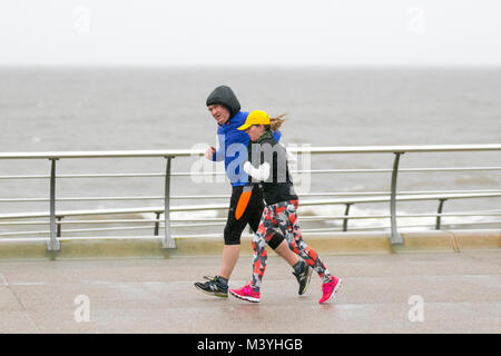 Blackpool, Lancashire. Feb 13, 2018. Météo France : froid, humide et venteux de commencer la journée, comme les coureurs prendre exercice léger, sur la promenade de front de mer. Normalement, un refuge pour la moitié des visiteurs à long terme cette ans pause à mi-parcours est sans l'Showzam événement qui permet de wow la foule dans les années précédentes. Des pluies torrentielles font qu'il est difficile pour les touristes et visiteurs qui se débattent avec les fortes rafales, et les rafales de vent. La prévision est de poursuivre et de fortes pluies persistantes souvent lentement vers l'est avec des vents forts. /AlamyLiveNews MediaWorldImages : crédit. Banque D'Images