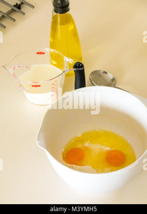 Préparation de la pâte à crêpes pour Mardi Gras avec la farine, le lait, les œufs et l'huile dans une cuisine maison Banque D'Images