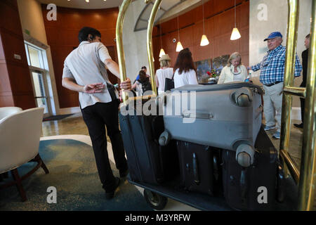 En Floride, aux États-Unis. Feb 13, 2018. Hall l'Ambassadeur Stephan Alvarado vous aider avec leurs bagages au Palm Beach Marriott Singer Island Beach Resort & Spa Le mardi 13 février 2018. Credit : Bruce R. Bennett/Le Palm Beach Post/ZUMA/Alamy Fil Live News Banque D'Images