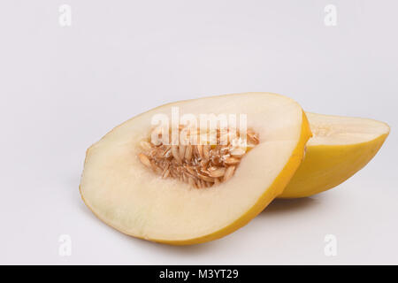 Deux morceaux de melon juteux, minces se trouve sur une grande peau jaune dans le coin inférieur droit sur un fond blanc, à gauche un espace vide pour le texte. Banque D'Images