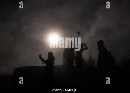 Silhouettes d'une équipe à un geyser smokey au Chili. Les chambres lumineuses de Sun Peaks à travers la fumée. Banque D'Images