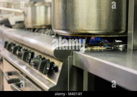 Détail d'une cuisinière à gaz allumé dans un restaurant de cuisine professionnelle Banque D'Images