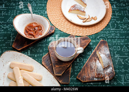 L'heure du thé. Confiture d'abricot, Tarte au fromage cottage et une tasse de thé sur les planches de bois. Des formules mathématiques sur fond nappe Banque D'Images