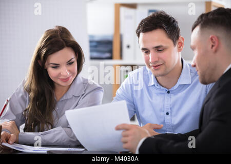 Couple Talking avec conseiller pendant Meeting in Office Banque D'Images