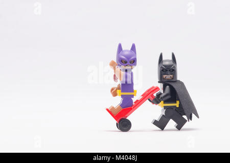 Lego Batman poussant chariot avec batgirl assis sur elle. isolated on white backgorund. Banque D'Images