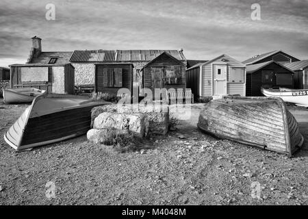 Vieux bateaux et cabines de plage à Portland bill en noir et blanc. Banque D'Images