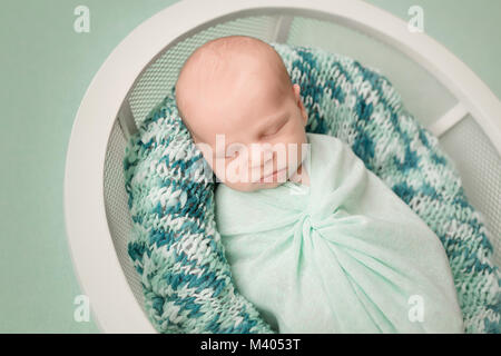 Sleeping newborn baby boy emmailloté dans une couverture Banque D'Images