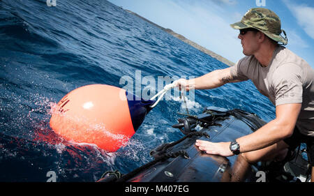 Technicien des explosifs et munitions 3 classe Jack Montgomery, affecté à l'unité mobile de destruction des engins explosifs (5 EODMU-5), les chutes d'une bouée pour marquer l'emplacement pour la lutte contre les mines sous-marines en formation Apra Harbour, Guam, 7 février 2018. EODMU5 mène des opérations contre les IED, rend les dangers d'un coffre-fort et désarme explosifs sous-marins. EODMU-5 est attribuée à commandant de la Force 75, la task force expéditionnaire principale responsable de la planification et l'exécution des opérations fluviales côtières, des explosifs et munitions, d'ingénierie et de construction, plongée sous-marine et constr Banque D'Images