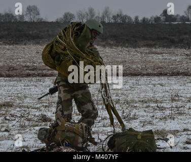 Un parachutiste de la 11e Brigade aéroportée française récupère son parachute après un atterrissage sur une zone de chute près de Ger, France. Les parachutistes français mènent à l'entraînement avec la 173e Brigade aéroportée américaine. Banque D'Images