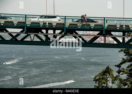 Vancouver, Colombie-Britannique, Canada. Vue de côté et la circulation cycliste sur le pont Lions Gate, le port de Vancouver en arrière-plan. Banque D'Images