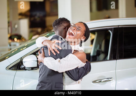 La collecte de couple nouvelle voiture de vendeur sur le lot Banque D'Images