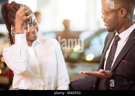 Vendeur de voiture en donnant une touche de nouvelle voiture à la belle african couple propriétaire Banque D'Images