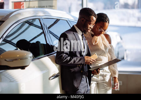 Marchand de voiture montrant véhicule pour femme noire Banque D'Images