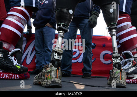 Patins portés par les Capitals de Washington pro joueurs de hockey flanquent le jambes artificielles de Michael Cain des guerriers USA hockey sur luge pendant une journée des médias pour l'hiver 2015 classique au Championnat National Park de Washington, D.C. le 31 décembre 2014. La Ligue Nationale de Hockey inclus le club de hockey les anciens combattants blessés en journée des médias, qui comprend de nombreuses entrevues avec les médias, aux côtés des Blackhawks de Chicago et les Capitals de Washington. (DoD News photo par EJ Hersom) 141231-D-DB155-001 par DoD Nouvelles Photos Banque D'Images