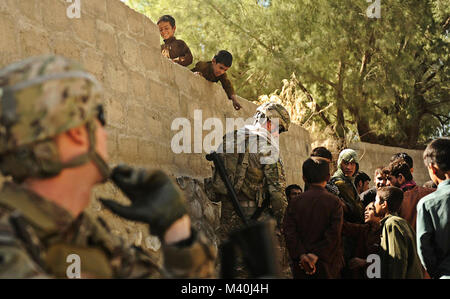 Un jeune garçon se penche sur un mur pour attirer l'attention du lieutenant-colonel Jayson Allen, Laghman, commandant de l'Équipe provinciale de reconstruction qu'il remet des fournitures scolaires à un groupe d'enfants pendant une patrouille dans le district de Mehtar Lam, province de Laghman. L'EPR s'est rendu dans le village de Deh E Ziarat de rencontrer le chef du village et les gens de parler de leur communauté. (U.S. Photo de l'Armée de l'air par le sergent. Ryan Crane, Laghman Affaires publiques de l'Équipe provinciale de reconstruction) 111014-F-RN211-108 par AirmanMagazine Banque D'Images