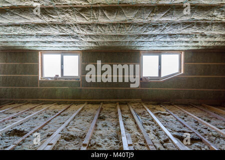 Chambre grenier en construction. L'isolation des murs et un plafond mansardé avec de la laine de roche. L'isolant en fibre de verre matériau dans le cadre en bois pour barrière froide. Banque D'Images