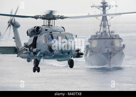 150811-N-XX566-010 OCÉAN PACIFIQUE (Août 11, 2015) - Un MH-60R Sea Hawk, affecté à l'hélicoptère de rapaces grève Maritime Squadron (HSM) 71 se prépare à terre à bord du USS JOHN C. STENNIS (CVN 74) comme l'USS Chung Hoon (DDG 93) suit derrière au cours d'une démonstration de force de démonstration. Les marins de la John C. Stennis Strike Group sont en cours de formation et d'exercice de l'unité composite Exercice d'une force opérationnelle (COMPTUEX/JTFEX), la dernière étape de la certification à déployer. (U.S. Photo par marine Spécialiste de la communication de masse de la classe 3ème Andre T. Richard / Relâché) 150811-N-XX566-010 par USS JOHN C. STENNIS (CVN 74 Banque D'Images