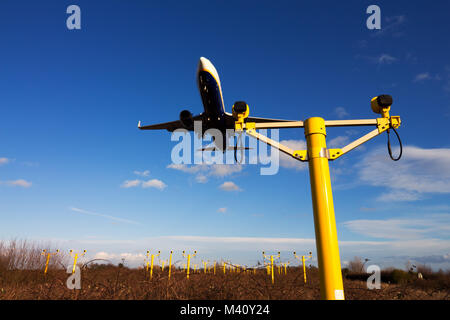 Un avion de Ryanair survolant le dispositif lumineux d'approche de la piste avant l'atterrissage. Banque D'Images