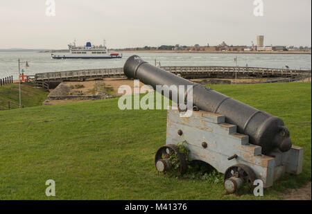 Vieux Canon naval à l'entrée du port de Portsmouth dans le Hampshire, en Angleterre. Avec l'île de Wight bateau sur l'eau Solent Banque D'Images