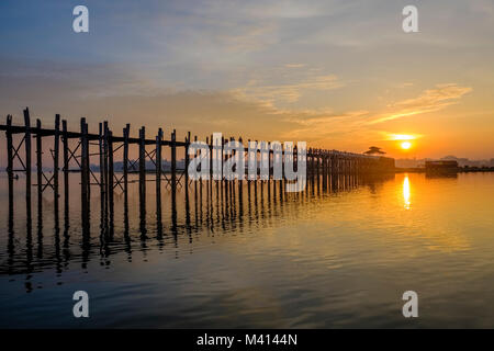 U Bein Bridge, un vieux pont en teck, reflète sur le lac Taungthaman au lever du soleil Banque D'Images