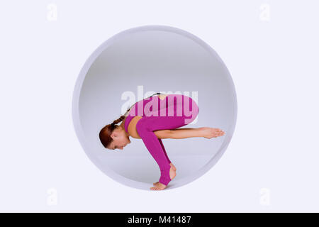 Belle et mince femme active wear, pratiquer les exercices de yoga dans la conception géométrique des formes rondes,en sphère. Sports concept créatif on white Banque D'Images