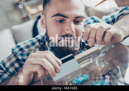 La photo en gros du toxicomane heureux joyeux excité avec barbe vêtu de chemise à carreaux, il prépare une chaîne de tri et la tenue d'un bankno laminées Banque D'Images