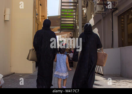 Moyen orient femme amener son enfant à l'extérieur, marcher dans une allée portant burqa Banque D'Images