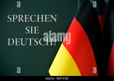 Quelques drapeaux de l'Allemagne et la question Sprechen Sie Deutsch ?, parlez-vous allemand ? Rédigé en allemand, contre un fond vert sombre Banque D'Images