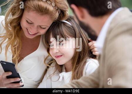 Bridge et le marié avec sa fille looking at smartphone Banque D'Images