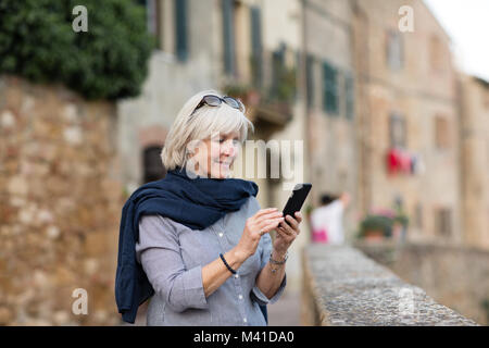 Senior woman en vacances à l'aide d'un smartphone Banque D'Images