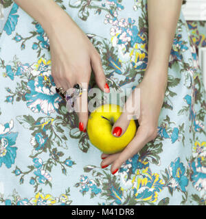 Woman's hands holding a green apple. L'art de la mode photo. Bijoux, beauté et manucure Banque D'Images