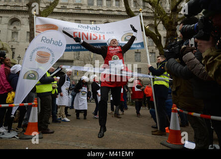 L'éditeur politique Tom Newton Dunn passe la ligne d'arrivée dans la course de crêpes au profit de l'organisme de bienfaisance, à l'invalidité Réadaptation Victoria Tower Gardens à Westminster, Londres. Banque D'Images