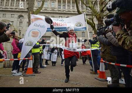 L'éditeur politique Tom Newton Dunn passe la ligne d'arrivée dans la course de crêpes au profit de l'organisme de bienfaisance, à l'invalidité Réadaptation Victoria Tower Gardens à Westminster, Londres. Banque D'Images