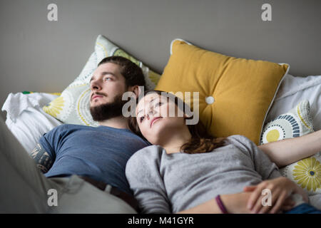 Young couple relaxing in bed Banque D'Images
