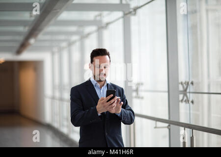 Businessman using smartphone app sur ses déplacements Banque D'Images