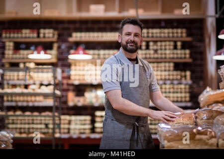 Baker dans une boulangerie à la recherche à l'appareil photo Banque D'Images