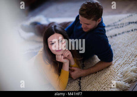 Couple lying on rug in new home Banque D'Images