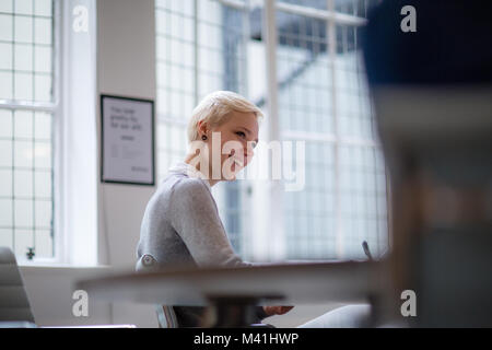 Jeune femme businesswoman taking notes in meeting Banque D'Images