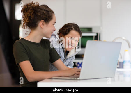 Sœurs using laptop together Banque D'Images