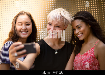 Amis féminins selfies posant pour une Banque D'Images