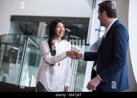 Businesswoman shaking hands with businessman Banque D'Images