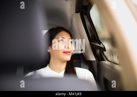 Businesswoman looking out de la fenêtre de taxi cab Banque D'Images