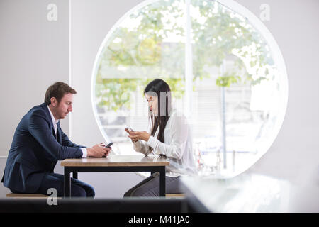 À l'aide de collègues dans un bureau smartphone Banque D'Images