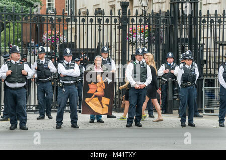 Poloitical artist Kaya Mar affiche une peinture de George Osborne avec ax et budget vide fort qui sort d'un cercueil pendant les handicapés contre les coupures protester à Downing St contre les coupes budgétaires qui frappent le plus durement les personnes handicapées. Banque D'Images